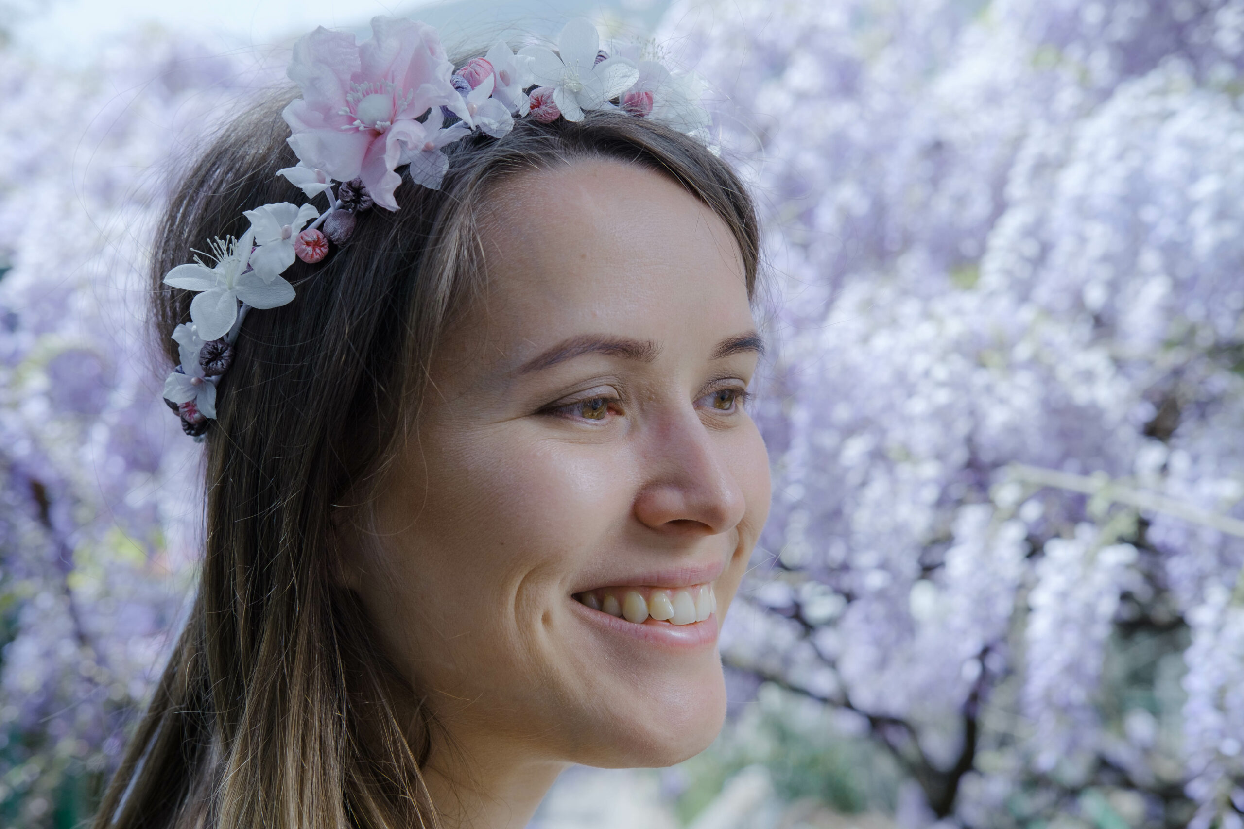 Femme souriante avec une couronne de glycine blanche